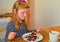 Little girl looking on her birthday cake. Small girl celebrating her six birthday. Little girl is eating cake