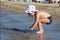 Little girl looking for shells on the beach