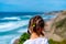 Little girl looking tropical sandy beach and ocean with turquoise water with waves