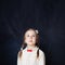 Little girl looking Up. Cute child on empty blackboard