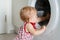 Little girl is looking into washing machine