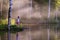 Little girl looks at beautiful lake with steam above water