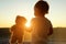 Little girl looks through window at sun and shows toy bear