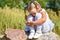 A little girl is lost in the street, sits on a rock and cries on a sunny day