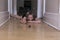 Little girl lying on corridor hardwood floor playing with small and large glass marbles