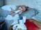 Little girl lying sick in bed blowing her nose feeling sick with high fever having a cold flu