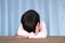 Little girl lying on the table in front of the blue curtain background pretending to sleep and refusing