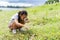 Little girl with magnifying glass looking for insects at meadow