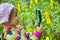 Little Girl with magnifying glass looks at flower