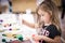 Little girl making handcraft at a table