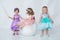 Little girl with a mask.Three little girls in beautiful dresses play in a white room