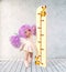 A little girl measures her height. Conceptual image of the process of growing up. 3D renderer