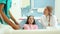 Little girl meeting friendly dental assistant while sitting in dental chair