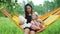 Little Girl with Mom Resting in Hammock Outdoors