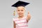 Little girl in mortarboard showing thumbs up