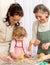 Little girl with mother cutting out cookies