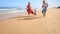 Little Girl Mother in Red Grandpa Run by Foamy Surf along Beach