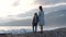 Little Girl with Mother Watching Sunset by a Sea