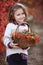 Little girl in a motley autumn park at sunset