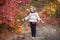 Little girl in a motley autumn park at sunset