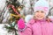 Little girl near christmass tree with bengal light