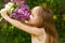 Little girl near lilac flowers snuff bouquet