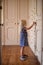 Little girl opening cabinet door in dressing room of large home