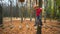Little girl in orange helmet and protective gear on rope-way in autumn  forest. smiling child engaged climbing rope park.