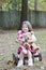 Little girl outdoors with toy monkey and bear