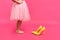 Little girl in oversized shoes with space for text, closeup on legs isolated on pink.