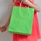 A little girl with a package in her hend enjoys shopping and sale on a light background. Child in good mood