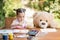 Little girl painting outdoor with her teddy bear friend