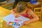 Little girl painting simple picture. Cute girl painting with watercolors