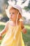 Little girl in a panama hat and a dress looks thoughtfully into the distance. Portrait