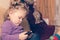 A little girl without parents` attention looks at the smartphone