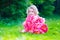 Little girl with peony flowers in the garden