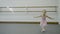 Little girl is performing dancing movements in ballet school.