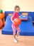 Little girl performs an exercise with a ball in the gymnasium