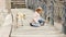 a little girl pets a stray cat on the bridge and the dog comes up and starts barking.