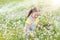 Little girl picking flowers in daisy field