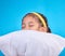 Little girl, pillow and sleep in a studio feeling tired, fatigue and ready for dreaming. Isolated, blue background and