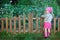 Little girl in pink boots near the fence