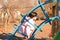 Little girl in a pink jacket climbs in a cage from pipes on the playground