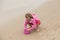 Little girl in pink playing with a pink bucket