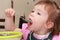 Little girl in pink shirt eating porridge