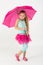 A little girl in pink skirt is chilly with umbrella