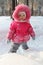 Little girl in pink stands in forest