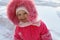 Little girl in pink stands and smiles in winter