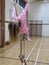 Little girl in pink swinging from ropes in the school gymnasium
