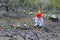 Little girl is planting tulips over burned ground